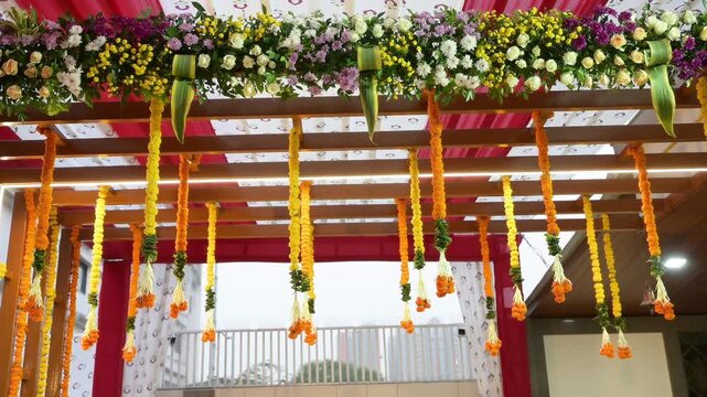 Colorful Floral Wedding Mandap With Hanging Marigold Garlands and Elegant Ceremony Decorations
