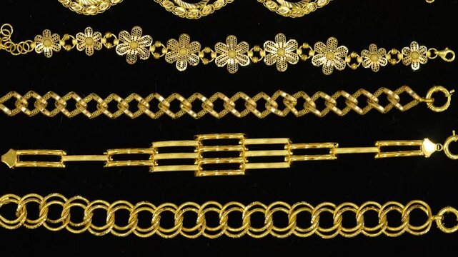 A refined collection of gold bracelets displayed on a black background, emphasizing detailed goldsmithing craftsmanship. Highlights luxury jewelry design, product variety, and premium presentation in 