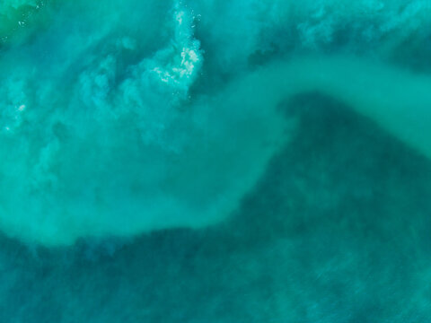 Aerial view of the swirling turquoise waters meeting in a mesmerizing dance of currents and hues, Kadrihnitin, Socotra, Yemen.