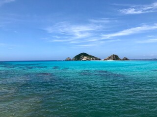 Naklejka premium Small Tropical Island Floating in Transparent Emerald Green Sea