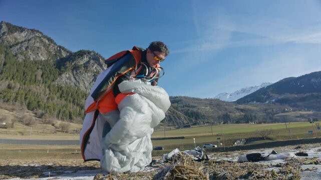 Wingsuit BASE jumper flying over Verbier surrounded by alpine mountains with snow-covered peaks. High-speed flight, dramatic scenery, and cinematic extreme sports action in the Swiss Alps.