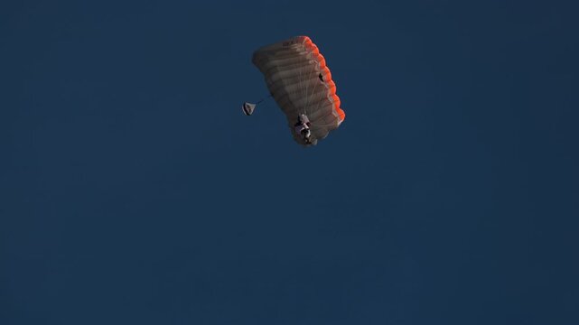 Wingsuit BASE jumper flying over Verbier surrounded by alpine mountains with snow-covered peaks. High-speed flight, dramatic scenery, and cinematic extreme sports action in the Swiss Alps.