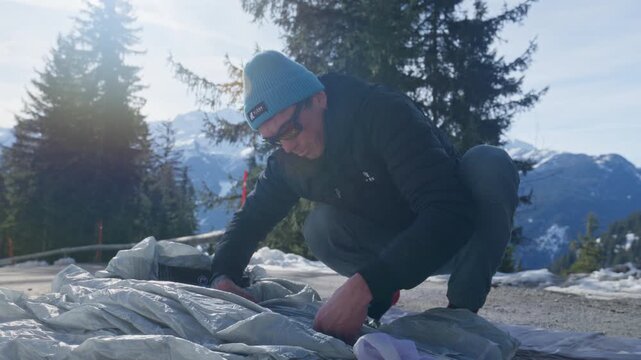 Wingsuit BASE jumper flying over Verbier surrounded by alpine mountains with snow-covered peaks. High-speed flight, dramatic scenery, and cinematic extreme sports action in the Swiss Alps.