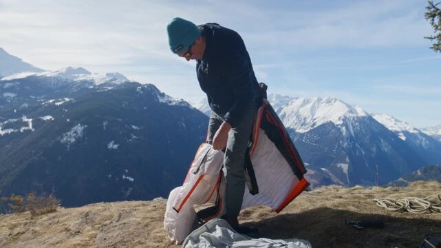 Wingsuit BASE jumper flying over Verbier surrounded by alpine mountains with snow-covered peaks. High-speed flight, dramatic scenery, and cinematic extreme sports action in the Swiss Alps.