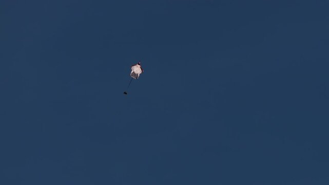 Wingsuit BASE jumper flying over Verbier surrounded by alpine mountains with snow-covered peaks. High-speed flight, dramatic scenery, and cinematic extreme sports action in the Swiss Alps.