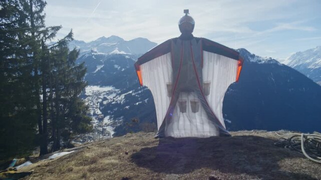 Wingsuit BASE jumper flying over Verbier surrounded by alpine mountains with snow-covered peaks. High-speed flight, dramatic scenery, and cinematic extreme sports action in the Swiss Alps.
