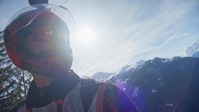 Wingsuit BASE jumper flying over Verbier surrounded by alpine mountains with snow-covered peaks. High-speed flight, dramatic scenery, and cinematic extreme sports action in the Swiss Alps.
