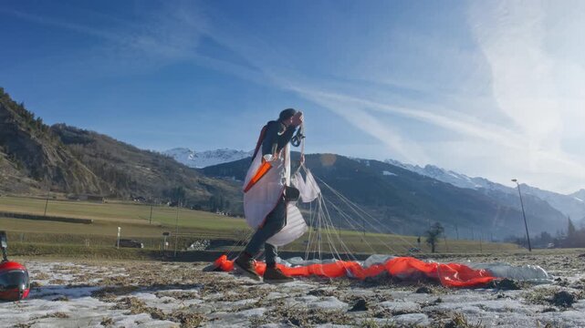 Wingsuit BASE jumper flying over Verbier surrounded by alpine mountains with snow-covered peaks. High-speed flight, dramatic scenery, and cinematic extreme sports action in the Swiss Alps.