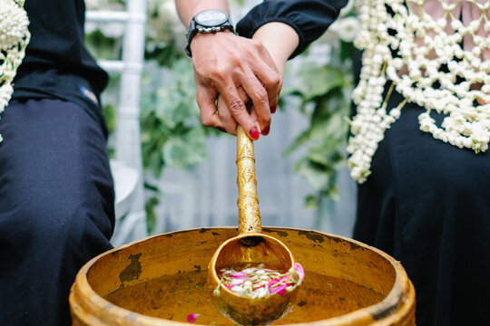 Close up of traditional Javanese wedding ritual Siraman with flower water.