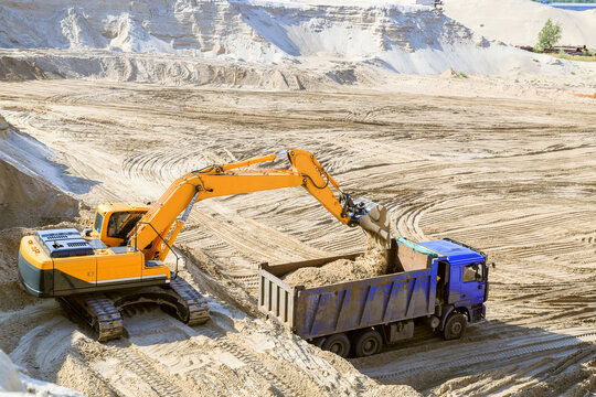 Work of the excavator and truck at a sand quarry.