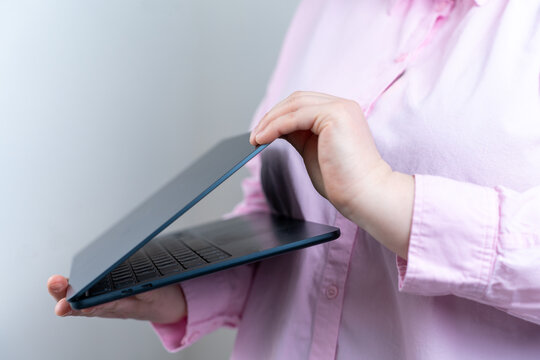 Woman opening laptop in minimalist workspace