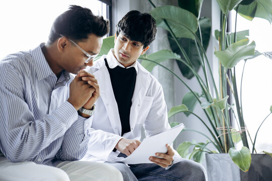 Doctor consulting male patient, explaining medical information, providing empathy and support during a difficult conversation
