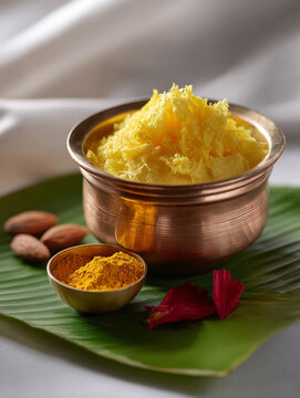 Traditional Makhan Malai Dessert in Brass Bowl on Banana Leaf with Spices and Almonds