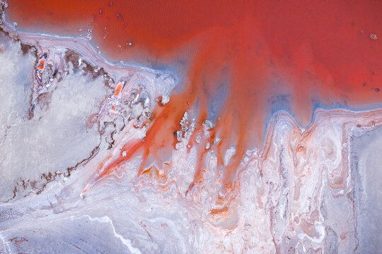 Aerial view of rust-colored waters meet the stark, white shoreline, creating a mesmerizing dance of color and texture in this unique landscape, Salt lake city, Utah, United States.