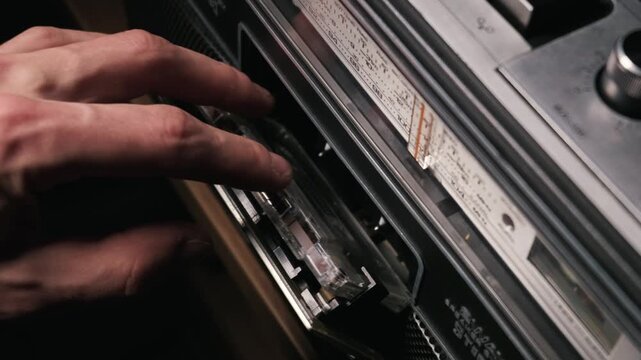 Empty cassette deck compartment stands open on a vintage analog radio player. This authentic retro technology evokes a nostalgic concept of classic analog audio listening.