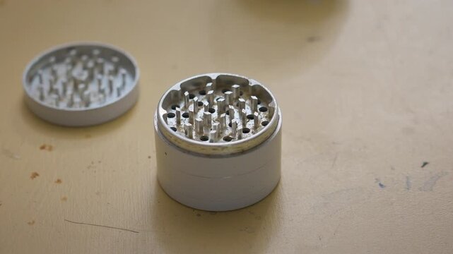 A white grinder for breaking down tobacco or cannabis.