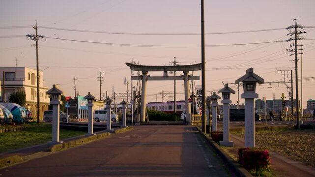 Sunset in Rural Japan, Train Passing Torii Gate in Peaceful Countryside Shrine