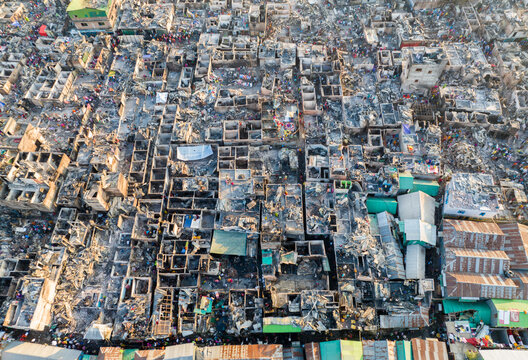 Aerial view of a densely packed urban landscape reveals a chaotic tapestry of rooftops and structures, painted in muted tones of grey and brown, Dhaka, Dhaka Division, Bangladesh.