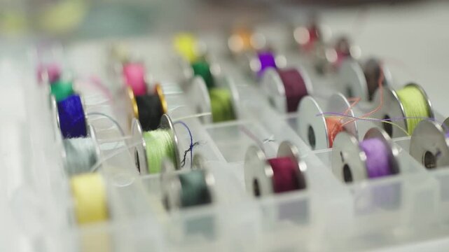 Colorful sewing thread spools arranged in rows textile pattern background