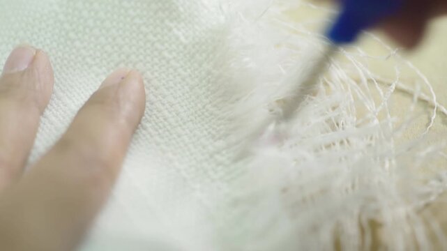 Removing loose threads from fabric close up garment finishing process