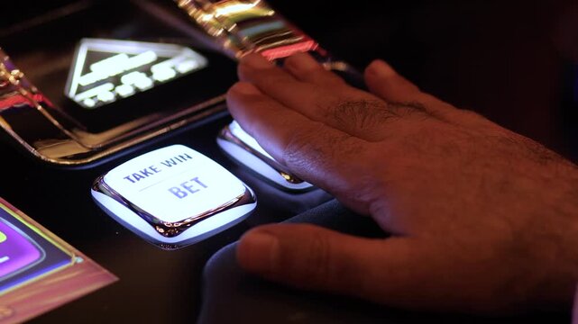 the hand presses the button on the casino slot machine