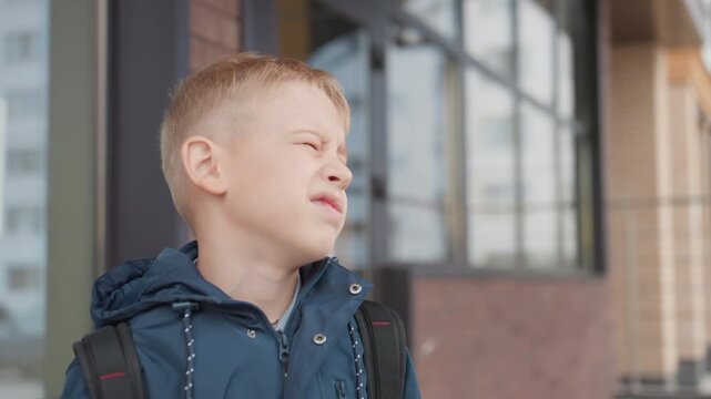 White boy reluctant to return school, closeup grimace and pout, hesitation at doorway with backpack on shoulders, emotional tension and quiet protest, urban apartment exterior, parents unseen