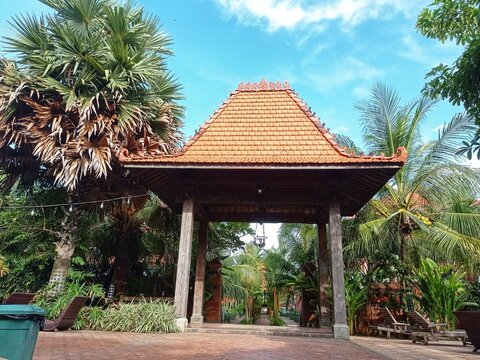 traditional joglo house in the middle of a garden and swimming pool