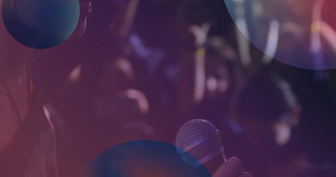 Animation of blue spheres over female caucasian singer performing to crowd
