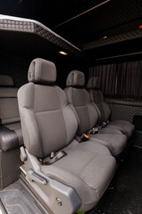 Naklejka premium Interior of Luxury Passenger Van with Grey Fabric Seats and Diamond Quilted Ceiling Lining