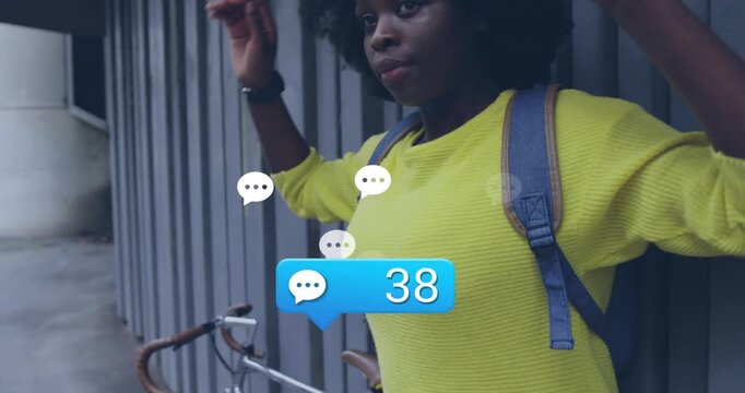 Woman by metal wall reacting to rising blue comment bubble, adjusting hair, smiling, social media