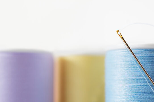 Studio shot of needle and colorful spools of threads