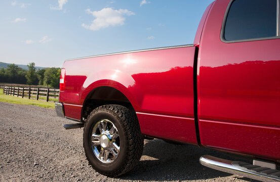 Red pickup truck on dirt road on sunny day