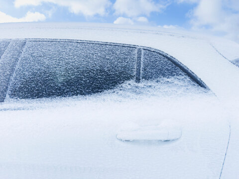 Close-up of compact SUV frozen in snow and ice