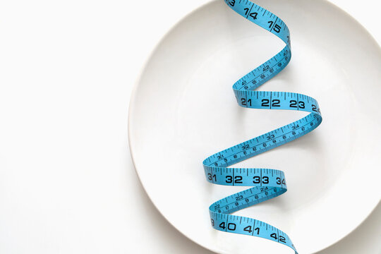 Blue tape measure on empty plate