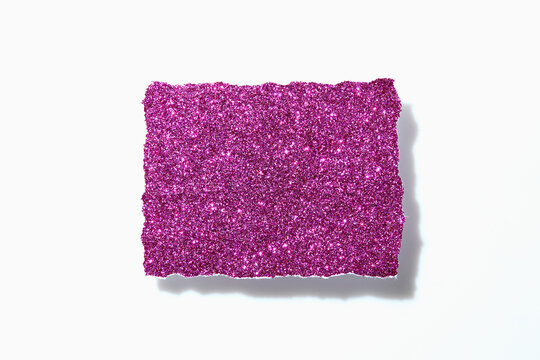 Torn pink glitter paper on white background