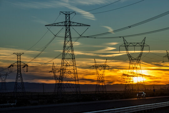 Electricity pylons and power lines at sunset