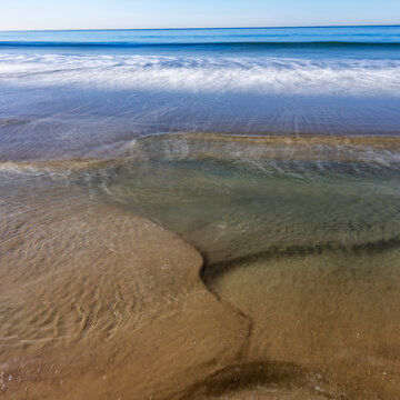 Motion blurred ocean waves on empty Santa Monica Beach