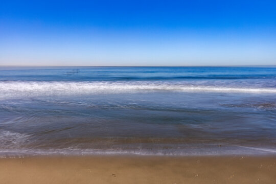 Calm ocean waves on empty Santa Monica Beach