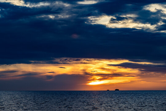Dramatic sky above calm sea oat sunset