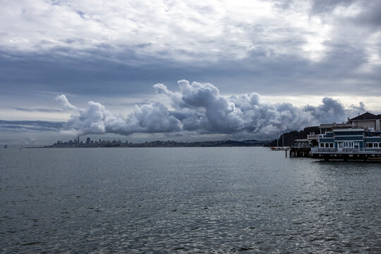 Puffy clouds above city skyline across bay