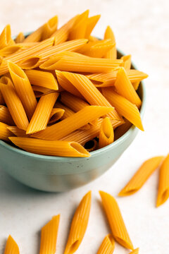 Uncooked chickpea penne pasta in a bowl 
