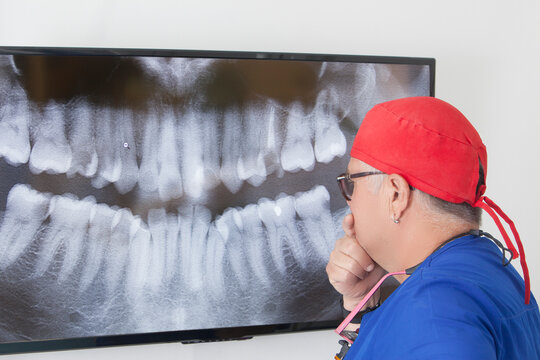 Dentist analyzing dental X-ray on screen