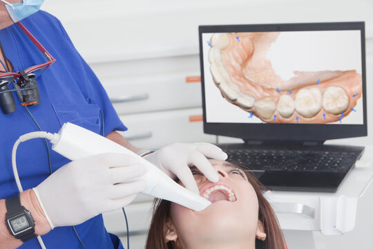 Dentist scanning female patients teeth with 3D scanner