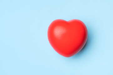 Obraz premium Red heart on blue background with space for text. Concept of medicine, health and cardiology. Healthy heart versus heart disease. Symbol of love. Flat lay top view