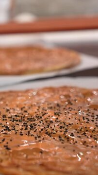 Vertical Close Up of Black Cumin Sprinkled on Tahini Pita Bread