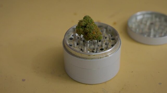 A nug of weed sitting on top of a grinder.