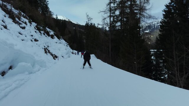 Skiers and snowboarders on a snowy forest trail at Grubigstein resort in the Austrian Alps. Shot on a smartphone