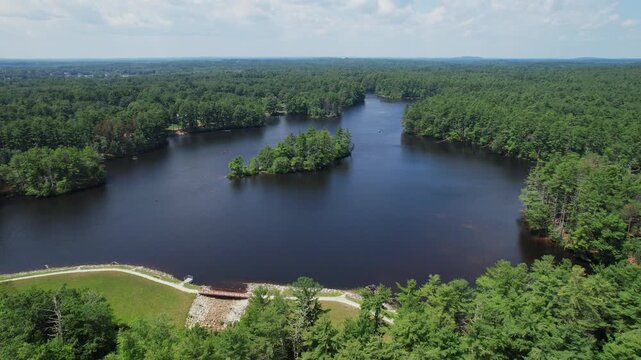 Lateral drone flight in Harold parker state forest with clear water and an island in the middle, epic landscape view surrounded by nature, Andover, MA