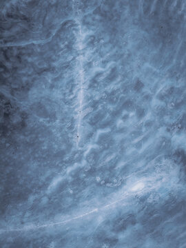 Aerial view of the stark, icy landscape with delicate patterns etched by wind and snow, Tind, Nordland, Norway.