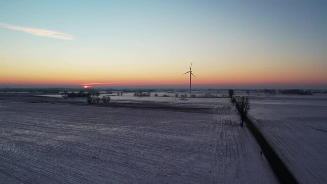 Sustainable energy in winter scenery &ndash; sunset over rural fields.